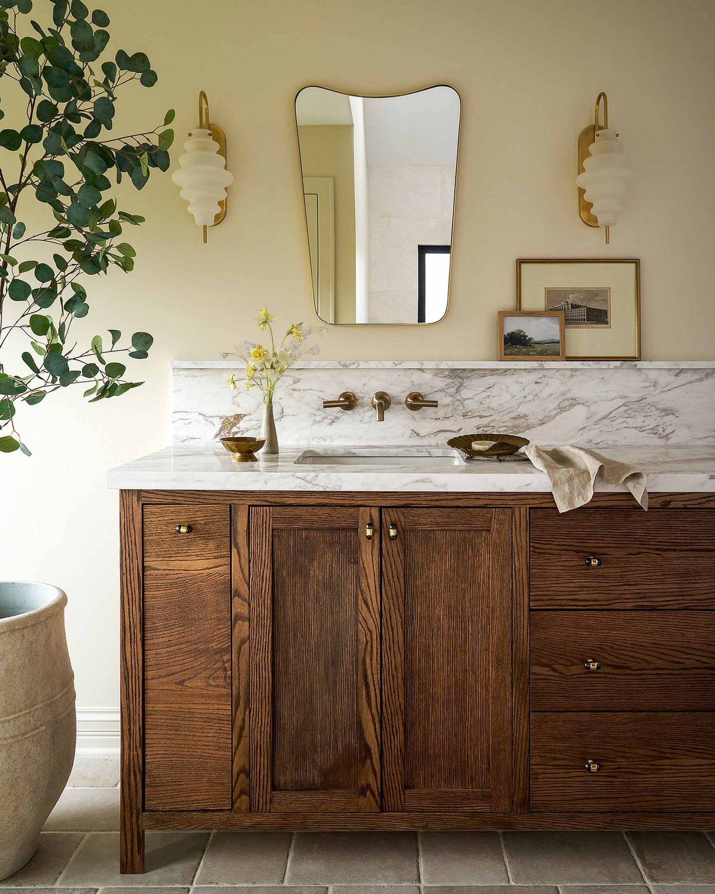 curved brass mirror in powder room