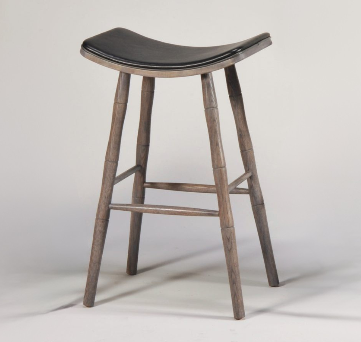 Wooden bar stool with a black cushioned seat on a white background