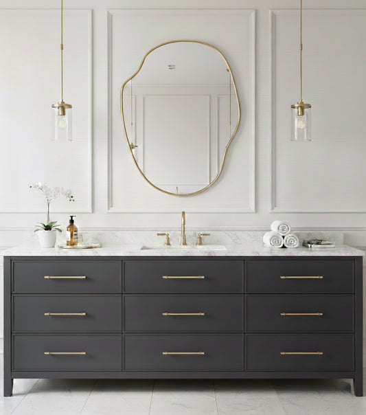 River stone brass mirror above dark gray double bathroom vanity.