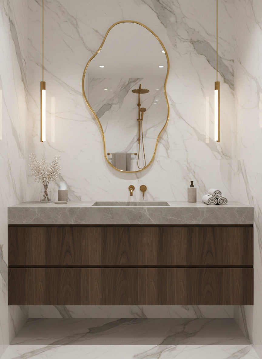 Organic brass mirror above marble vanity

