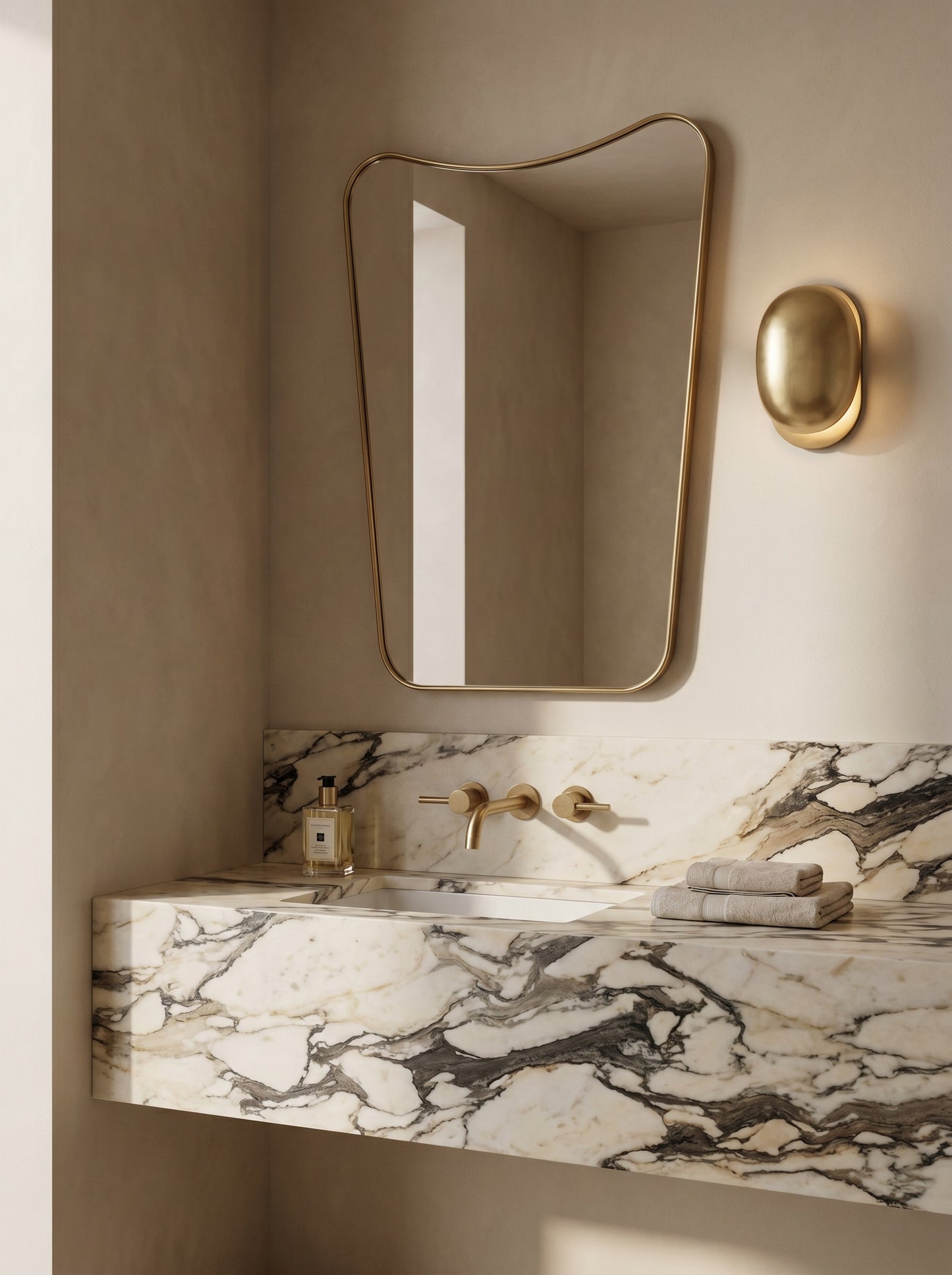 Organic brass mirror above floating marble vanity