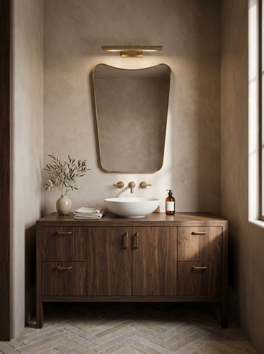Modern brass wall mirror above walnut bathroom vanity
