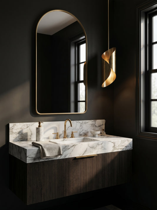 Minimal arched brass mirror above floating marble vanity in dark bathroom