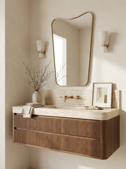 Soft scalloped brass mirror above fluted walnut vanity