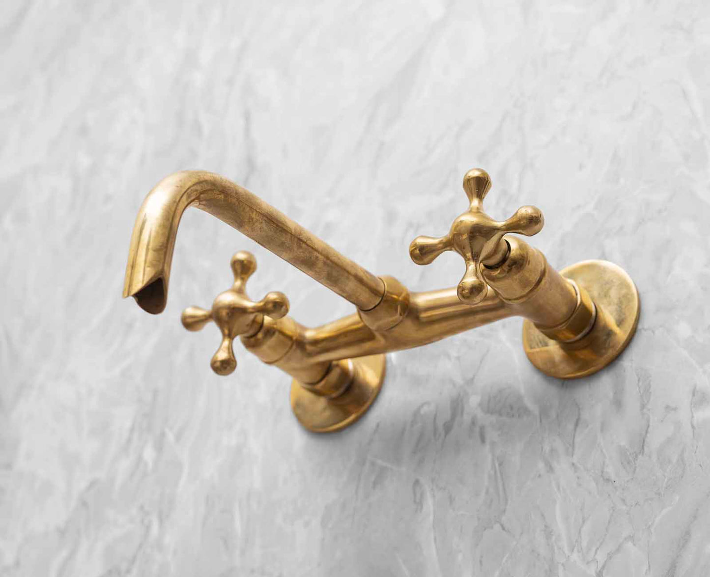 a golden faucet on a white marble counter top