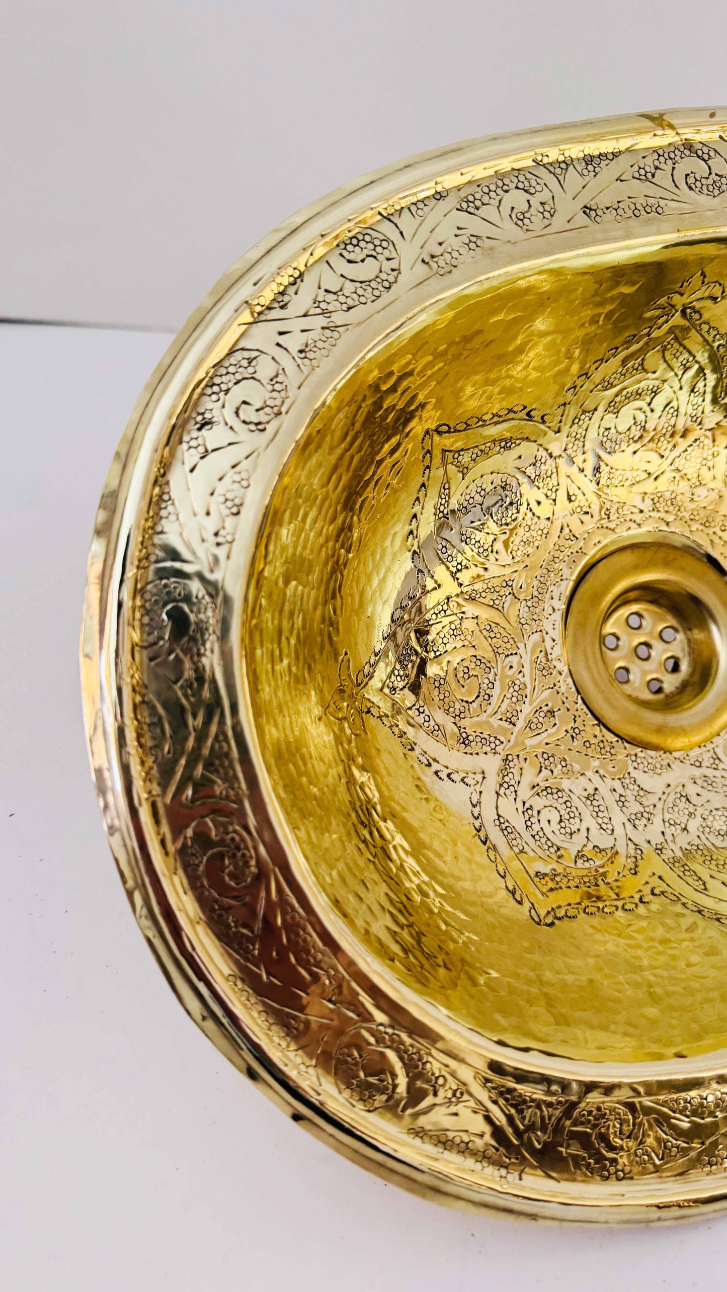 a golden bowl shaped like a bowl on a white surface