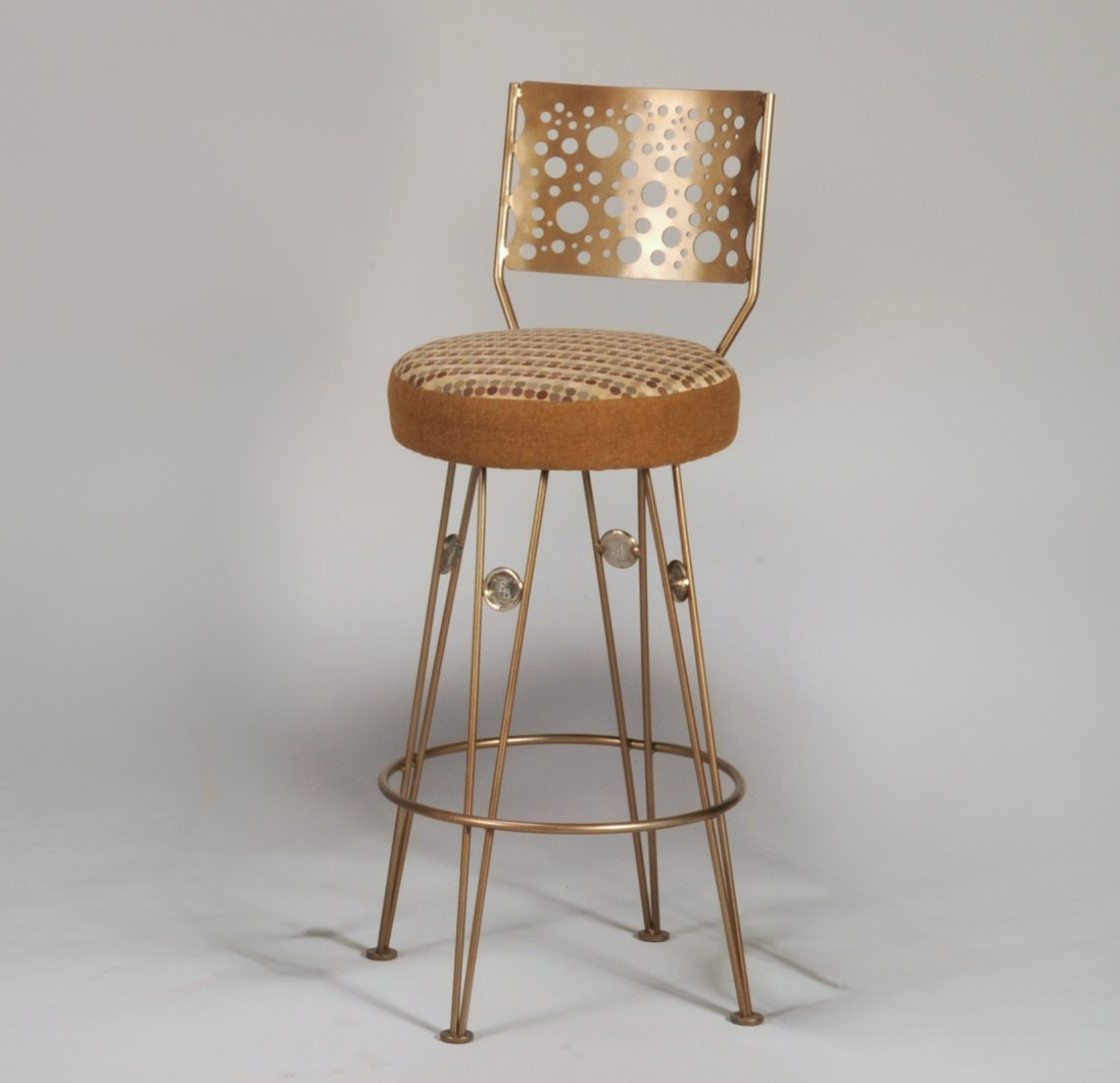 Bronze bar stool with perforated backrest on a gray background
