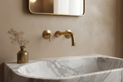Close-up of marble sink with brass wall-mounted faucet