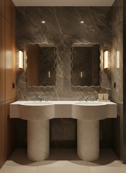 Twin wavy silver brass mirrors above double pedestal sinks.
