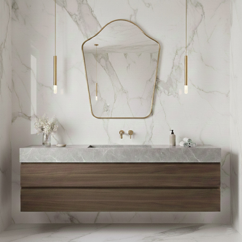 Arched top brass mirror above floating wood vanity on marble wall