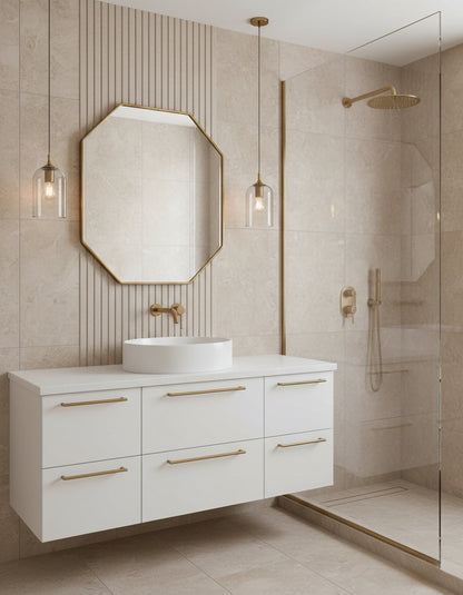Octagon brass mirror above white floating vanity with glass shower.