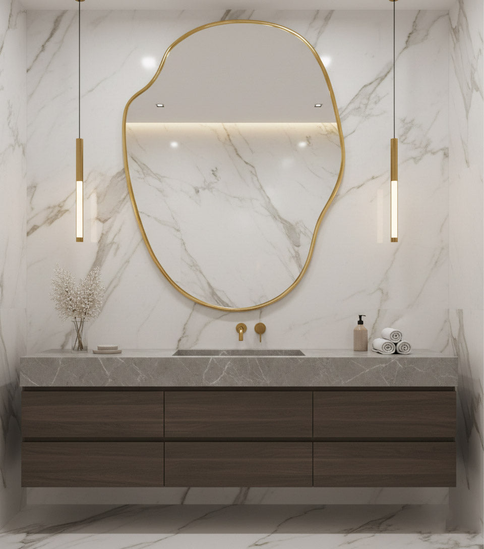 Large river stone brass mirror above marble bathroom vanity.