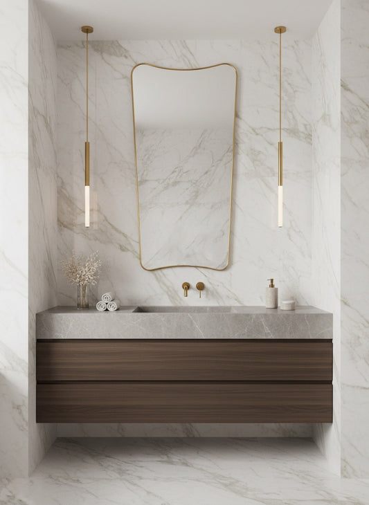 Organic brass wall mirror above floating vanity in a modern marble bathroom