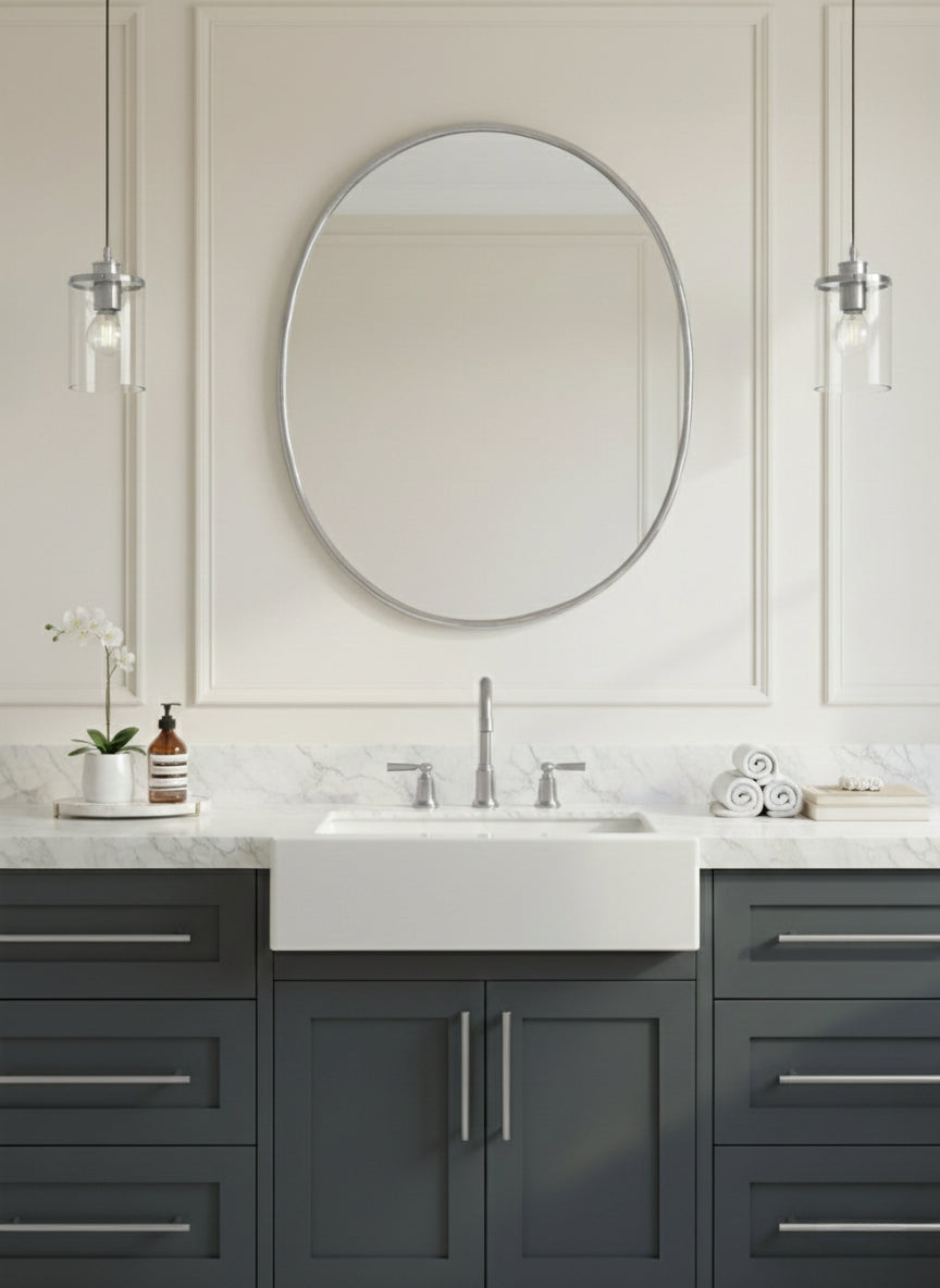 Minimal oval mirror over gray vanity in a classic bathroom.