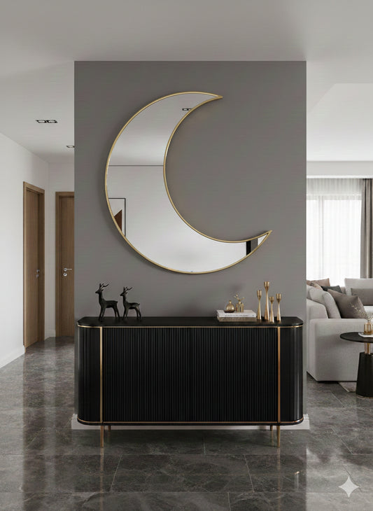 Gold crescent moon mirror above black console table