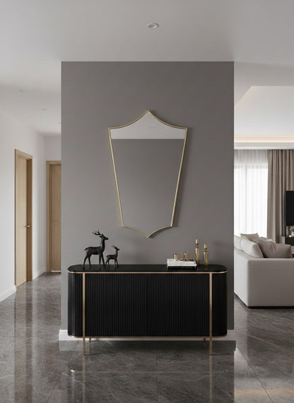 Modern shield-shaped brass mirror in minimalist living space