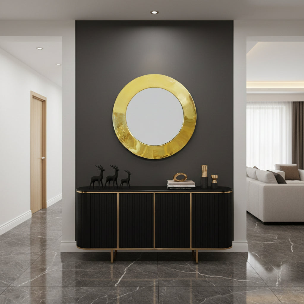 Round gold mirror above black console.