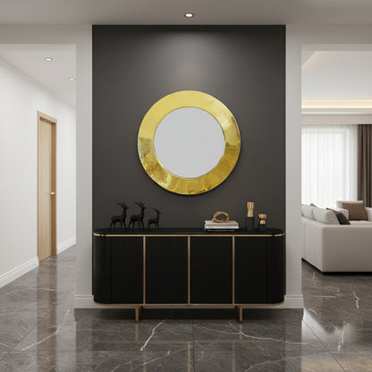 Round gold mirror above black console.