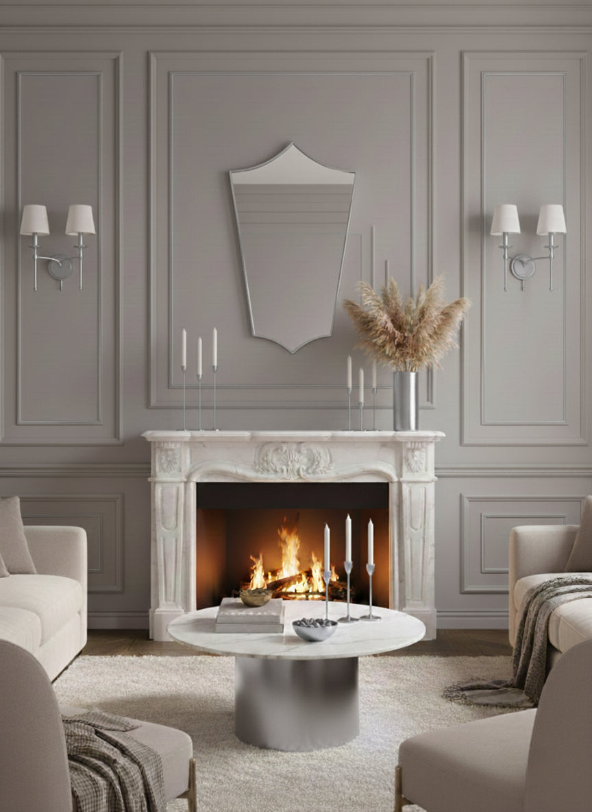 Decorative shield mirror above marble fireplace in a cozy living room.