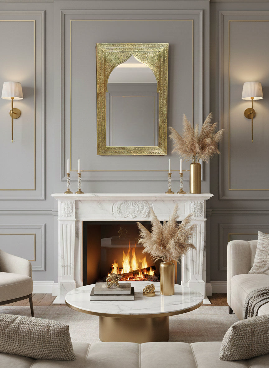 Carved arch brass mirror styled over a classic fireplace