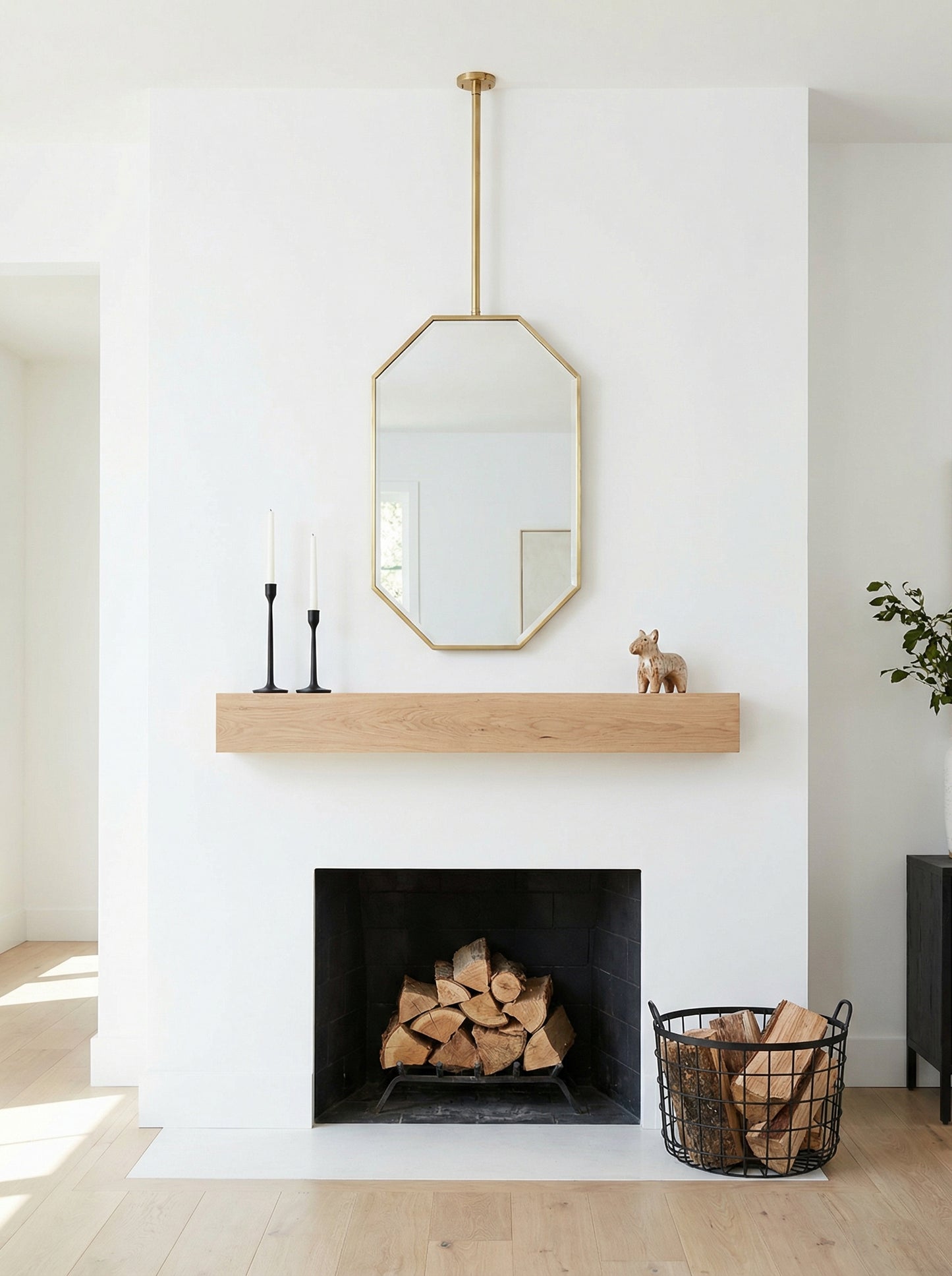Handmade octagon brass mirror suspended above fireplace mantel