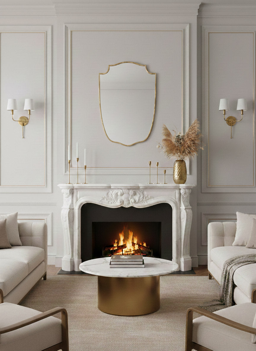 Brass shield mirror above white marble fireplace.