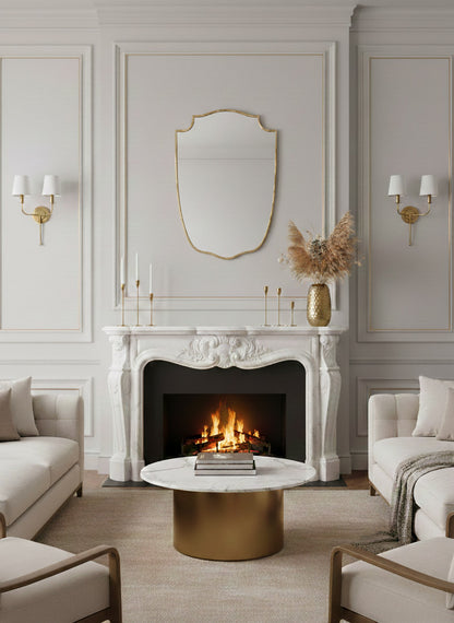 Brass shield mirror above white marble fireplace.