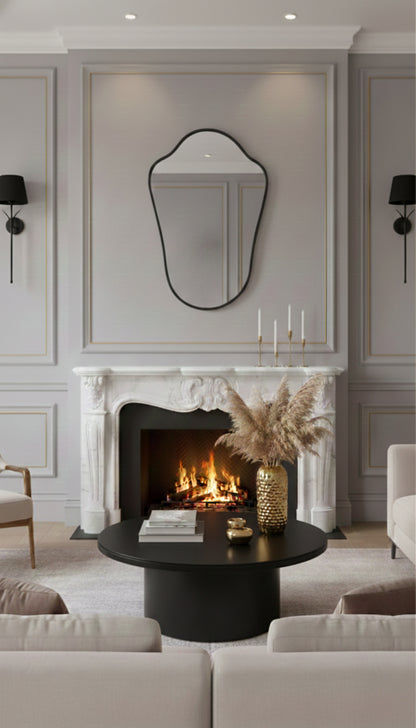 Black shield wall mirror above fireplace mantel