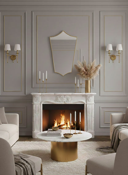 Decorative shield brass mirror above marble fireplace mantel