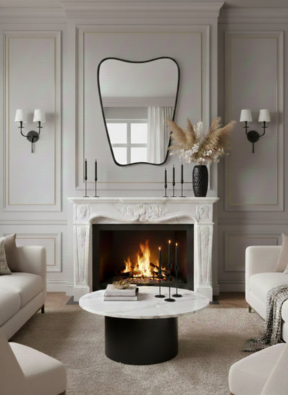 Wavy black mirror above classic white fireplace mantel in elegant living room.