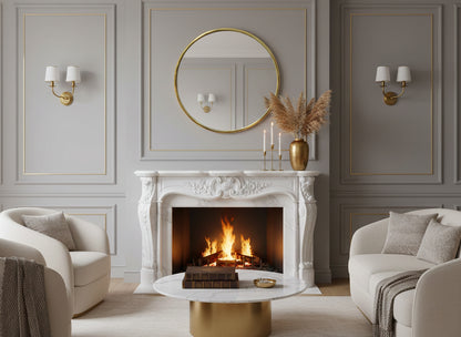 Round brass wall mirror above an ornate white fireplace mantel in a classic neutral living room.