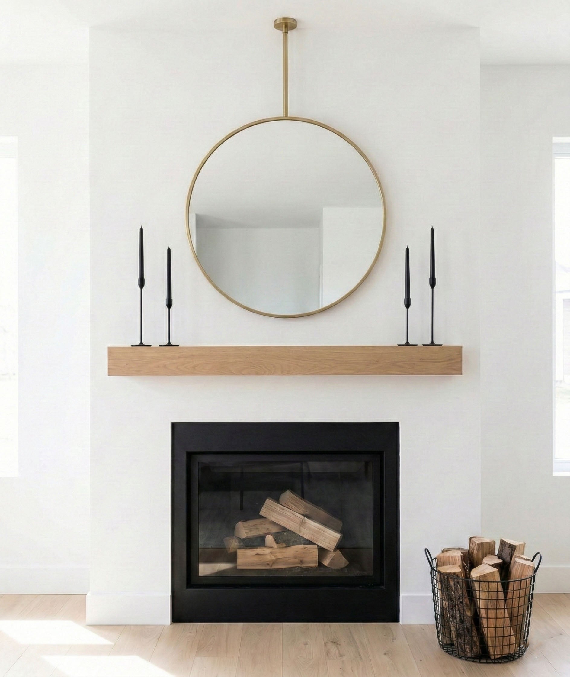 Hanging round brass mirror styled above fireplace mantel