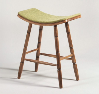 Wooden stool with a green cushioned seat on a light gray background