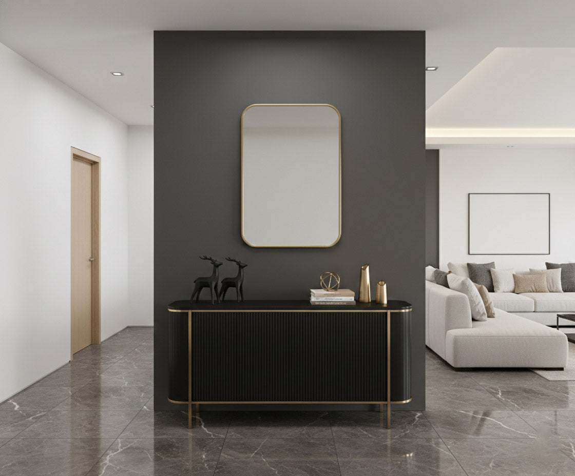 Rectangular brass mirror above black console table.