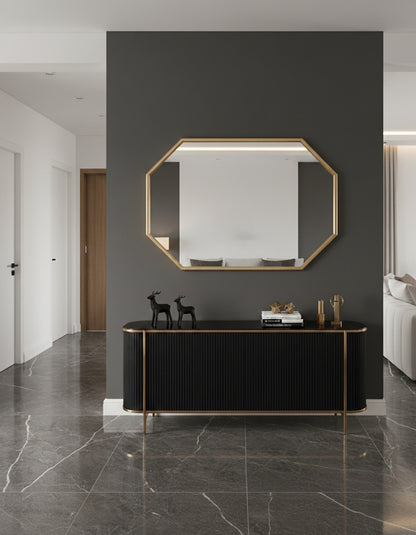 Octagon brass mirror above black console table.