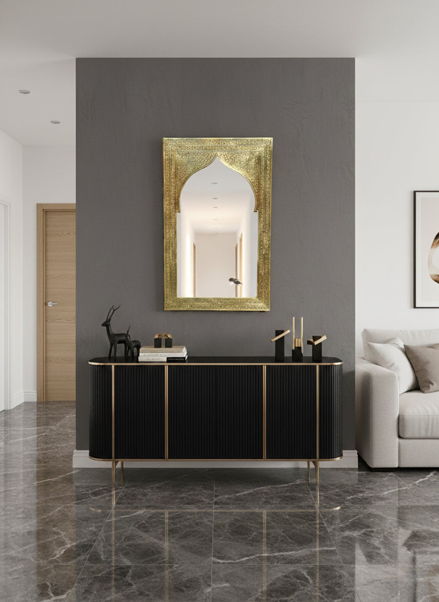 Carved arch brass mirror above a modern console table