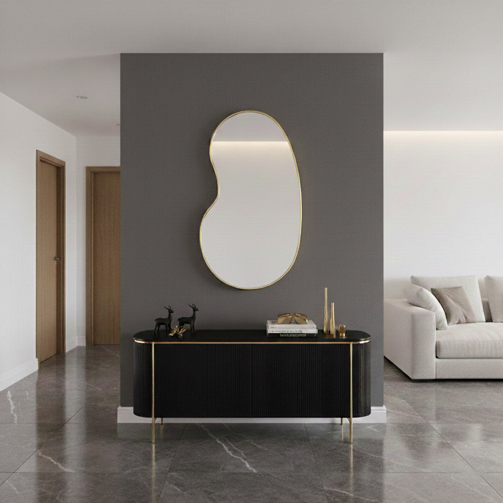 Kidney-shaped mirror above black console table.