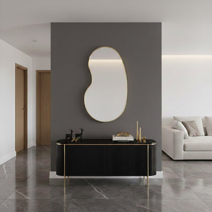 Kidney-shaped mirror above black console table.