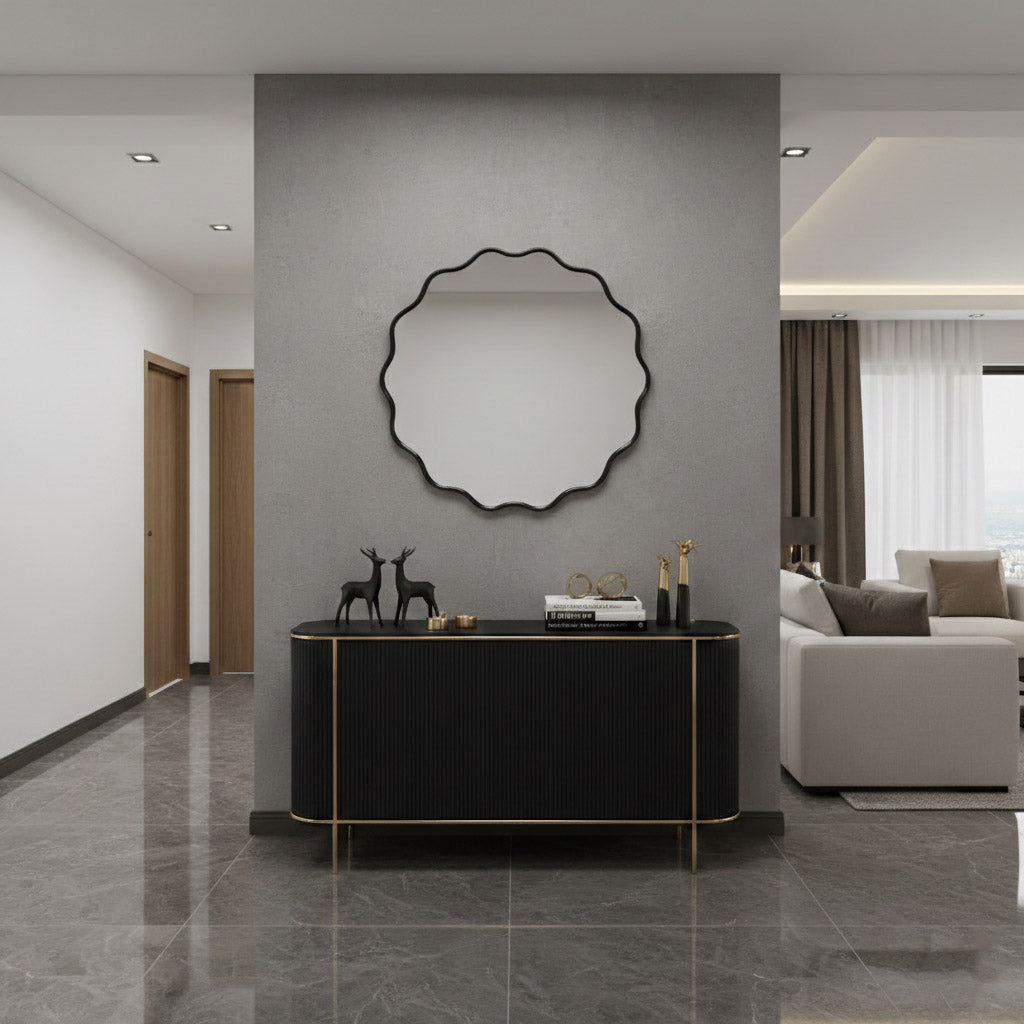 Round wavy black wall mirror above black console in contemporary hallway.