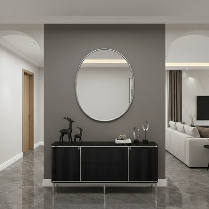 Oval wall mirror above black console in a modern hallway.