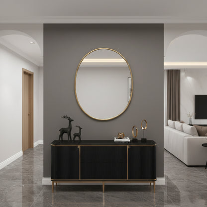 Oval brass wall mirror styled above a modern console table