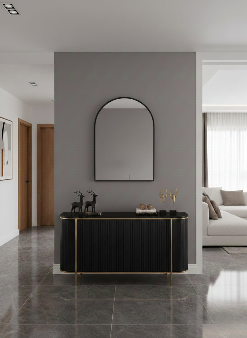 Italian arch brass mirror above black console
