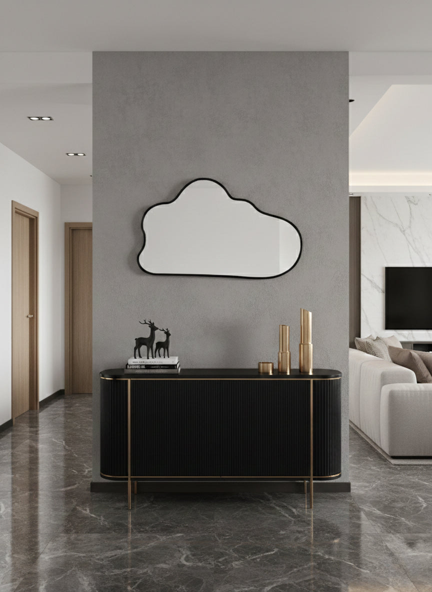 Black asymmetrical wall mirror above console table.