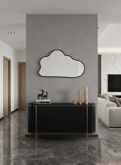 Black asymmetrical wall mirror above console table.
