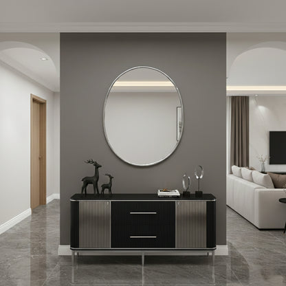 Silver brass oval mirror mounted above black console in modern entryway.