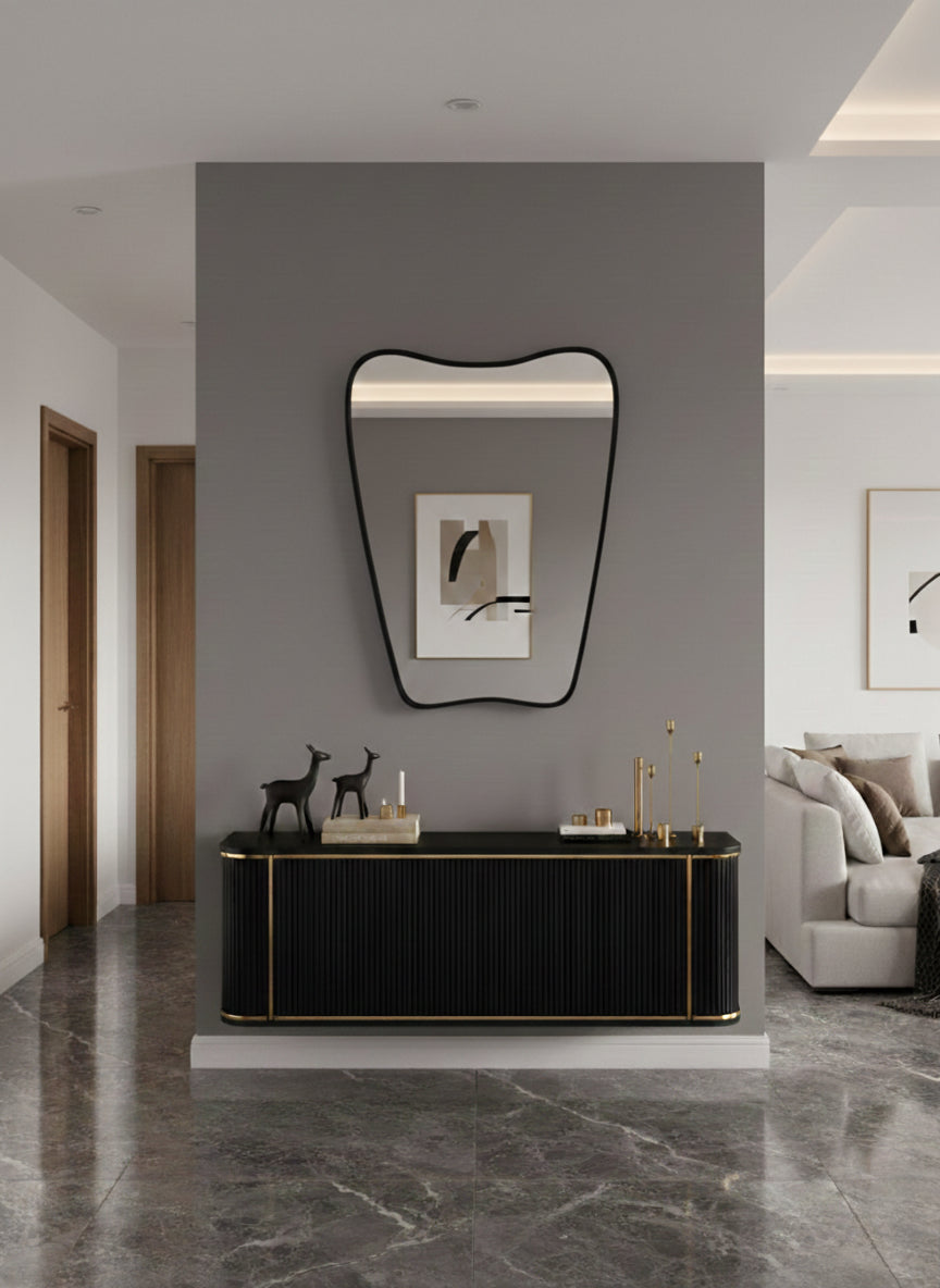 Organic black wall mirror above modern console in minimalist hallway.