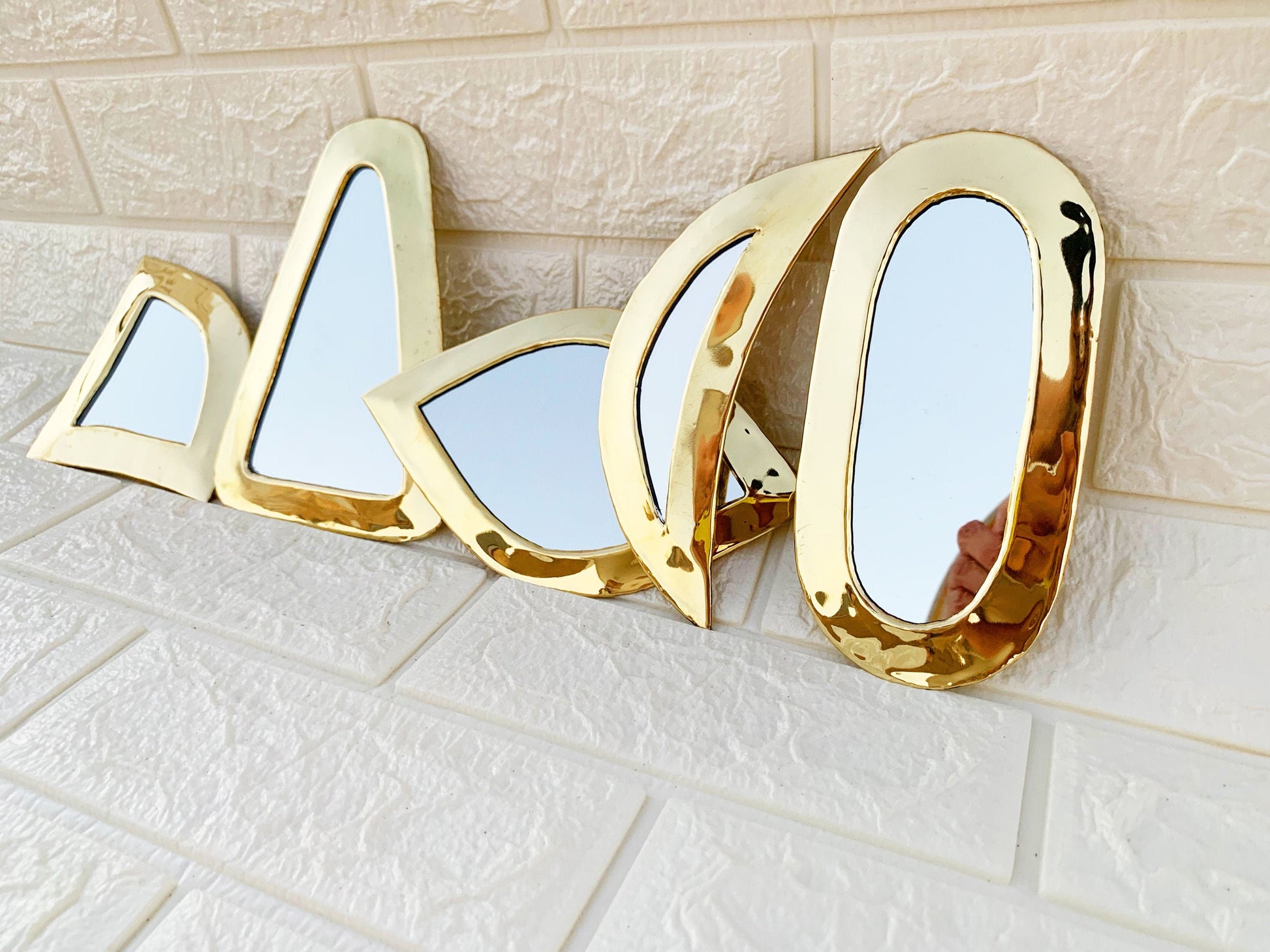 a set of three mirrors mounted to a wall