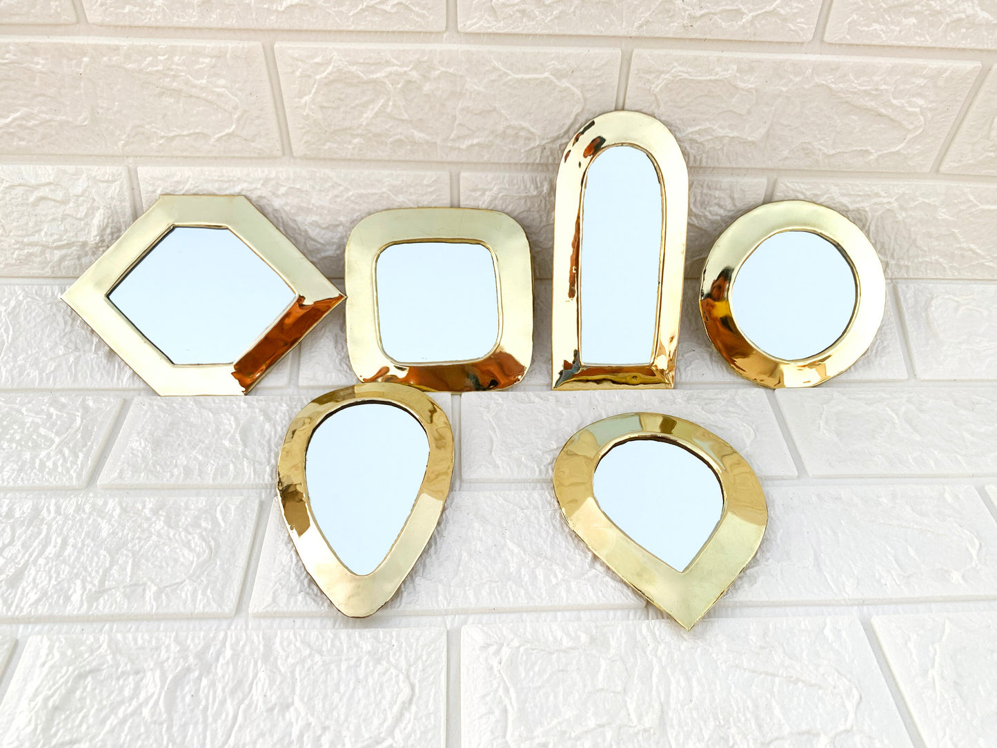 a group of mirrors sitting on top of a white tiled floor