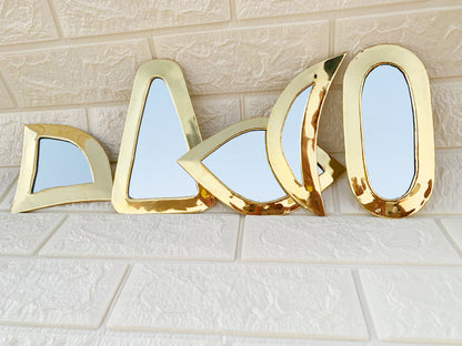 a gold mirror sitting on top of a white tile floor