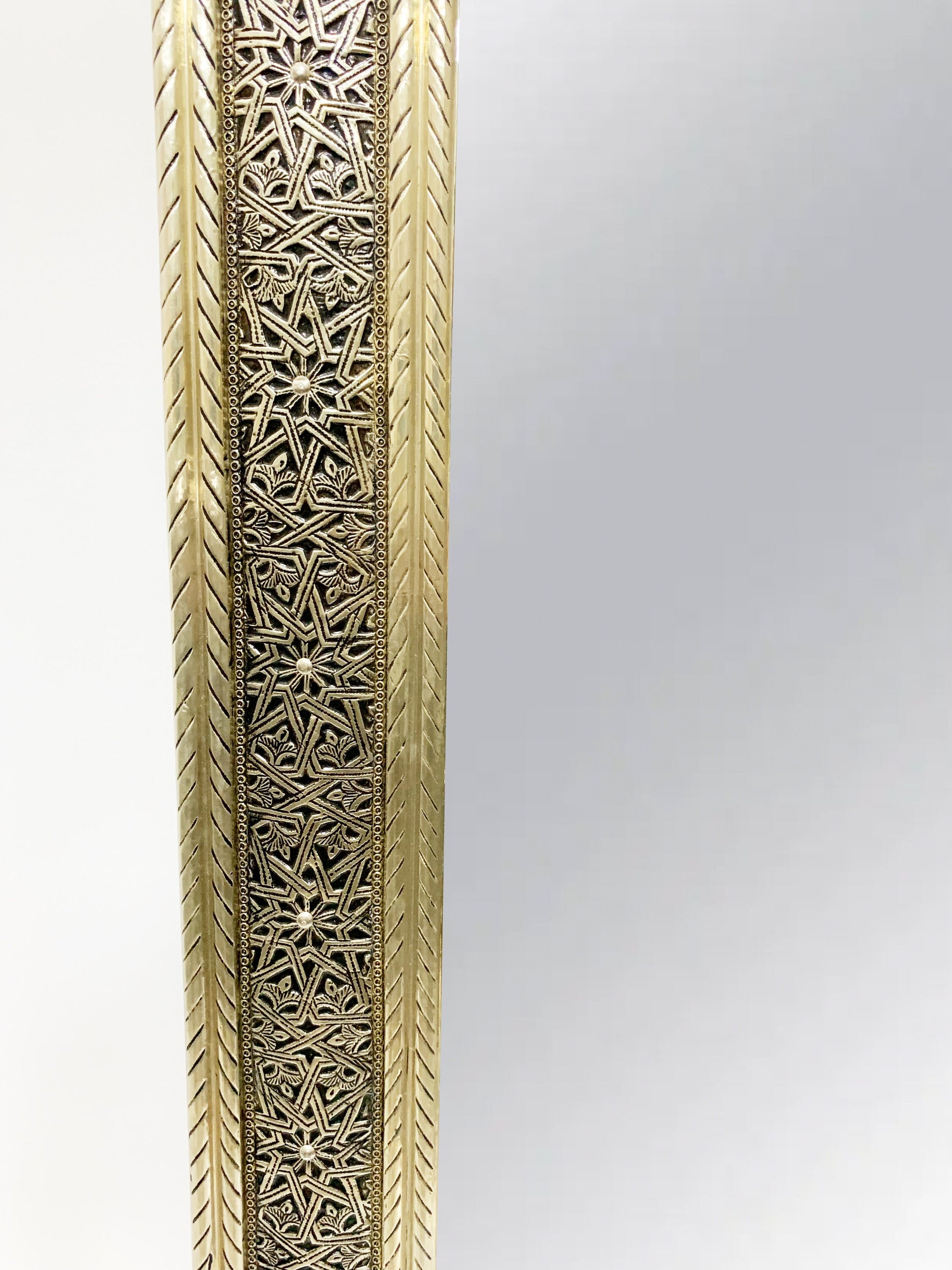 a tall metal vase with intricate designs on it